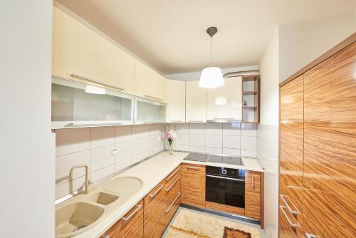 una cucina con elettrodomestici bianchi e mobili in legno di RIVER VIEW Apartments a Sarajevo