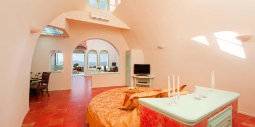 a bedroom with a bed in a room with windows at Vallas Apartments & Villas in Firostefani