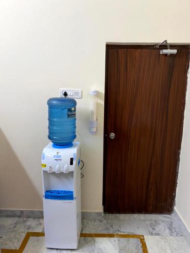 a door with a water container on top of a refrigerator at Backpackers Den in Lucknow