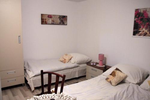 a bedroom with two beds and a table with a chair at Apartament U Jacka 2 in Rabka