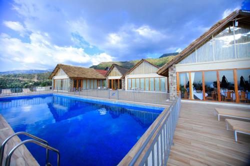a house with a large blue swimming pool at Mezena Resort & SPA in Lalībela