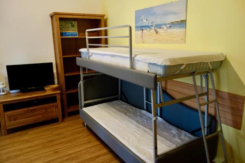 two bunk beds in a room with a tv at Appartamento Holiday Rimini 100mt dal mare in Rimini