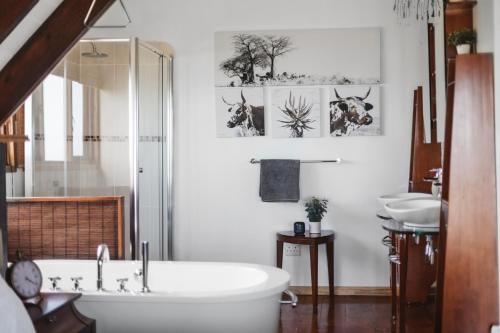 uma casa de banho com uma banheira, um WC e um lavatório. em Surf Lodge South Africa em Jeffreys Bay