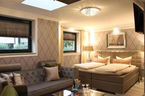 uma sala de estar com um sofá e uma cama em Hotel Villa Sommer em Bad Doberan