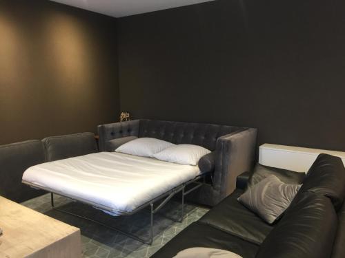 a couch and a bed in a room at Deluxe Apartment with Shared Pool in Ostend