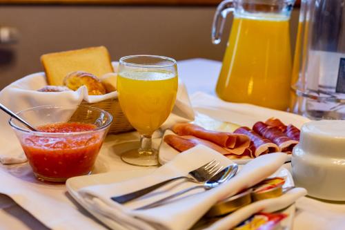 a table with a plate of food and a glass of beer at Hotel de Montaña Rubielos in Rubielos de Mora