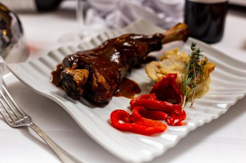 a plate of food with meat and vegetables on a table at Hotel de Montaña Rubielos in Rubielos de Mora