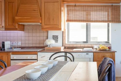 una cocina con una mesa con tazones blancos. en Escape to Paradise, en St Paul's Bay