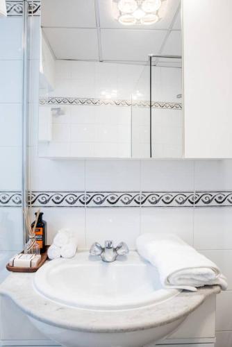 a white bathroom with a sink and a mirror at Escape to Paradise in St Paul's Bay