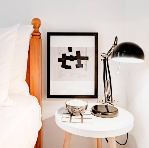 a bedside table with a lamp and a bowl on it at Escape to Paradise in St Paul's Bay