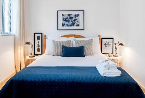 1 dormitorio con 1 cama azul y blanca y 2 lámparas en Escape to Paradise, en St Paul's Bay