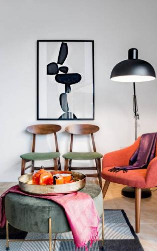a living room with two chairs and a table with fruit at Escape to Paradise in St Paul's Bay