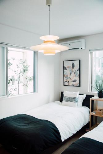 a bedroom with two beds and a ceiling fan at villa okinawa onna in Onna