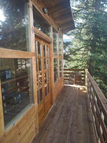 a porch of a wooden cabin with a bench at Kedra Village in Kédra