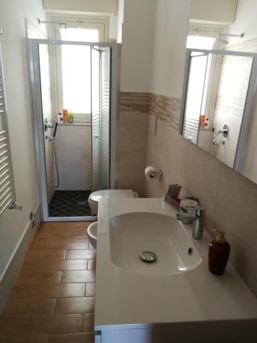 a bathroom with a sink and a toilet and a shower at Casa Levante Sea View Apartment in Catania