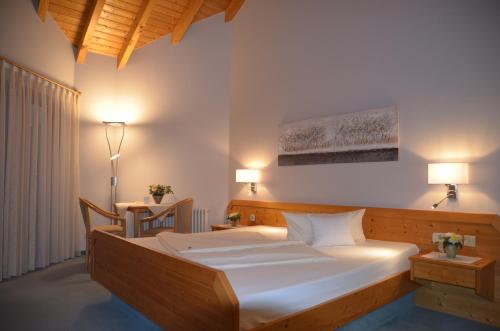 a bedroom with a large bed and a table at Hotel-Pension Breig Garni in Ottenhöfen