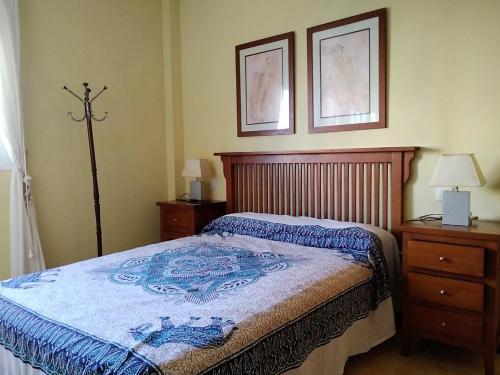 - une chambre avec un lit, 2 commodes et 2 photos dans l'établissement Jardín del Mar, à La Manga del Mar Meno
