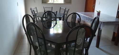 - une table à manger noire avec des chaises noires et un comptoir dans l'établissement Pousada Rio Novo Jalapão, à Mateiros