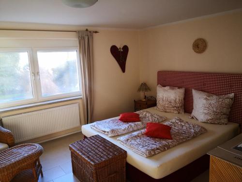 クルンペンドルフ・アム・ヴェルターゼーにあるHoliday Apartment Krumpendorfのベッドルーム1室(赤い枕のベッド2台付)