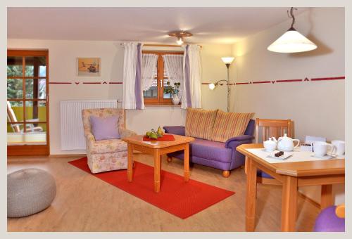 a living room with a purple couch and a table at Landhaus Marie-Theres in Oberstdorf