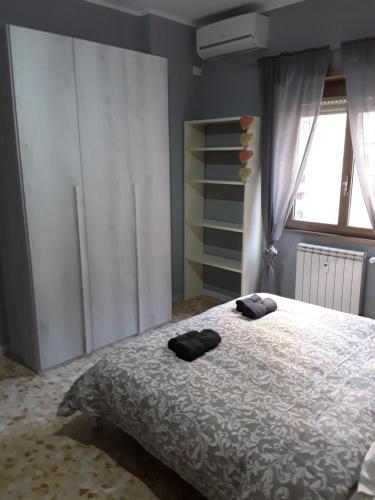 Un dormitorio con una cama con dos zapatillas negras. en Casa galletti, en Roma