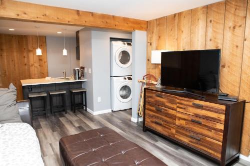 een woonkamer met een televisie en een wasmachine bij 6 Chamonix Lane 1 Bedroom Townhouse in Vail