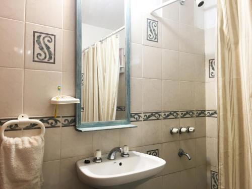 ein Badezimmer mit Waschbecken und Spiegel in der Unterkunft La Susy in Mar del Tuyú