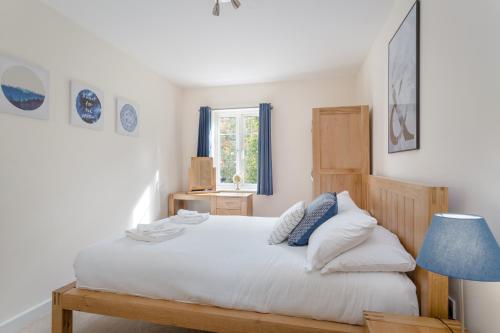 a bedroom with a white bed with a blue lamp at Luxury Hitchin Apartment, Great Town Centre Location - With Parking in Hitchin