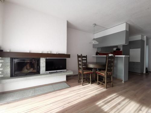 a living room with a table and a fireplace at Appartementhaus-Quadern in Valens