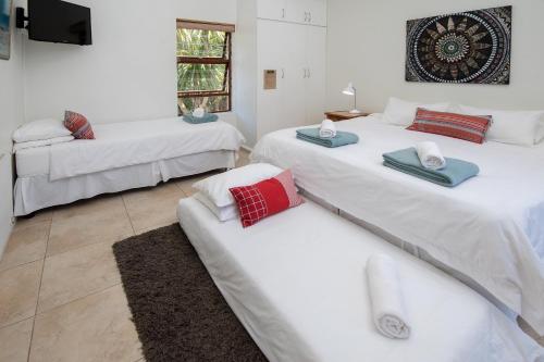 a room with two beds and a tv at Aloe Again in Jeffreys Bay