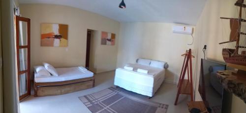 a living room with two beds and a window at Abrolhos Dive Inn in Caravellas