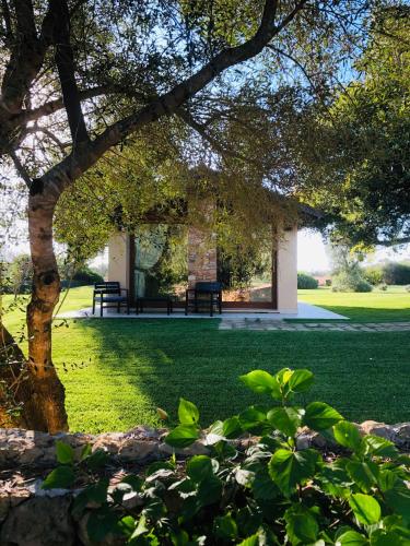a park with two benches and a tree at Inghirios Wellness Country Resort in Santa Maria la Palma