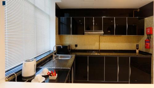 a kitchen with a sink and a counter top at Samaya Hotel Apartment Dubai in Dubai