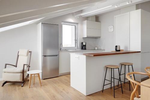 a kitchen with white cabinets and a bar with stools at H SUITE3B by Smiling Rentals in Hondarribia