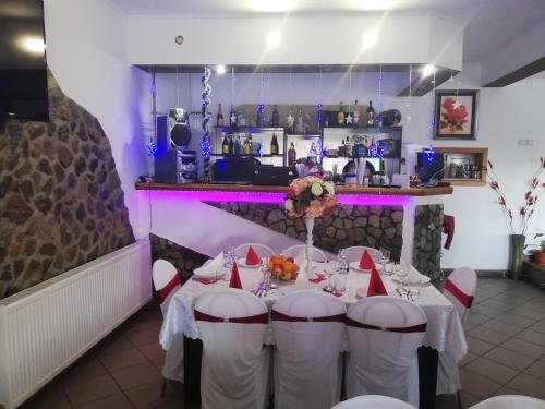 a dining room with a table with chairs and a bar at Restaurant Vi La Maria in Baia de Fier