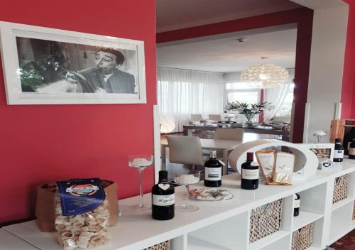 a room with a white counter with wine bottles on it at Hotel Storyville - svago e convenzioni aziendali in Cinquale