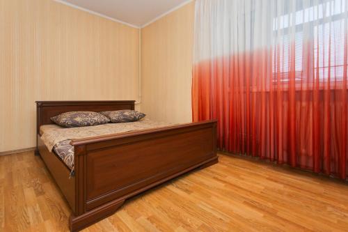 a bedroom with a bed and a red curtain at 2 room in Centre on Troitskaya 3 floor in Sumy