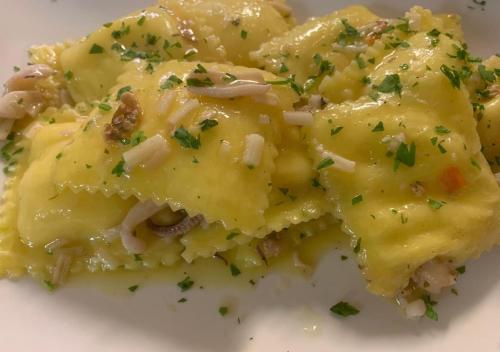 a white plate of food with cheese and onions at Hotel Storyville - svago e convenzioni aziendali in Cinquale