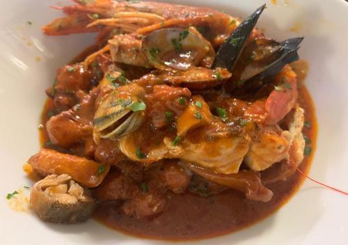 a white plate of food with meat and mushrooms at Hotel Storyville - svago e convenzioni aziendali in Cinquale