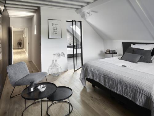 1 dormitorio con 1 cama, 1 silla y 1 mesa en Ask Lily, en Westmeerbeek