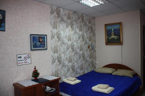 a bedroom with a bed with a blue comforter at motel Pid Strihoyu in Kremenchuk
