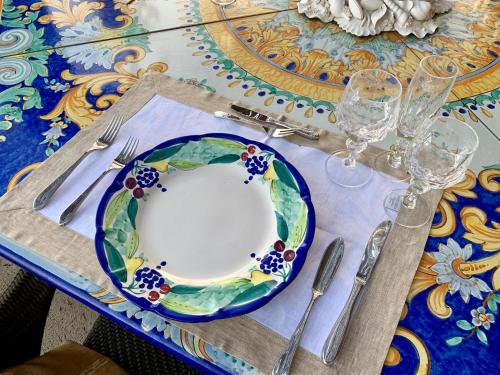 a table with a plate and wine glasses on it at Villa Le Baste in Furore