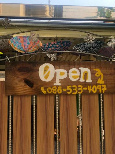 a sign that says open on a wooden door at Baan Tepa Boutique House in Bangkok