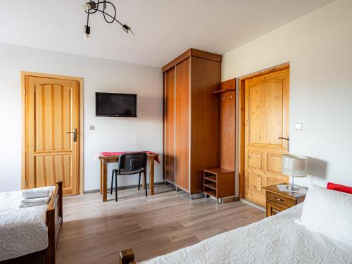 a bedroom with a bed and a desk with a table at Dom Wypocz Pod Litwinką Apartamenty in Białka Tatrzanska