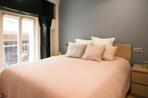 a bedroom with a large bed with white sheets and a window at Apart 2 Opera New 2-3 Rooms for 4 guests in Paris