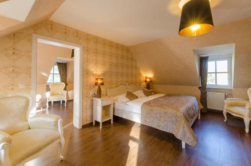 um quarto com uma cama, 2 cadeiras e um espelho em Seeschloss Schorssow em Schorssow