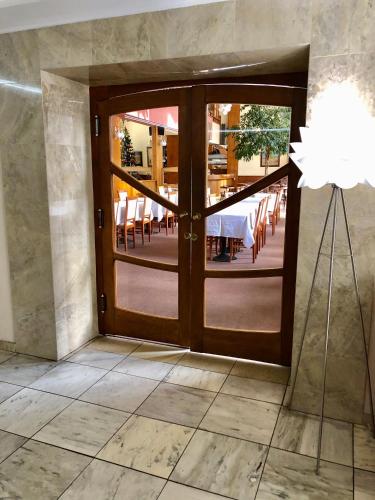 an open door to a dining room with a table and chairs at Hotel & Penzión Grand Matej in Banská Štiavnica