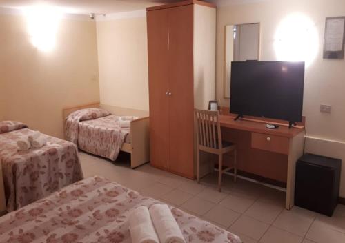 a hotel room with two beds and a television at Hotel Storyville - svago e convenzioni aziendali in Cinquale