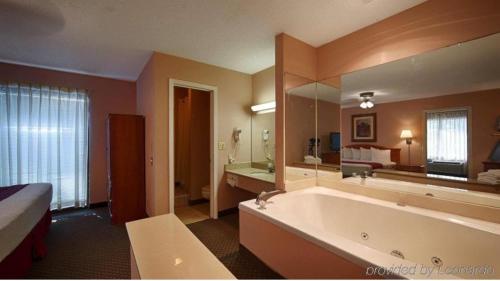 a bathroom with a large tub and a large mirror at The Parkwood Inn & Suites in Mountain View