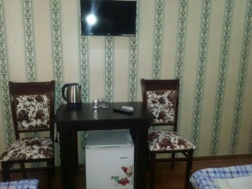 a room with a table and two chairs and a television at Отель RATMINA- MUINAK in Mŭynoq